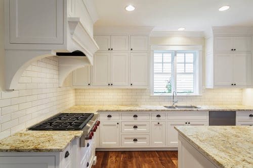 Bright white kitchen with a professional range, prepared and styled for a real estate photo shoot